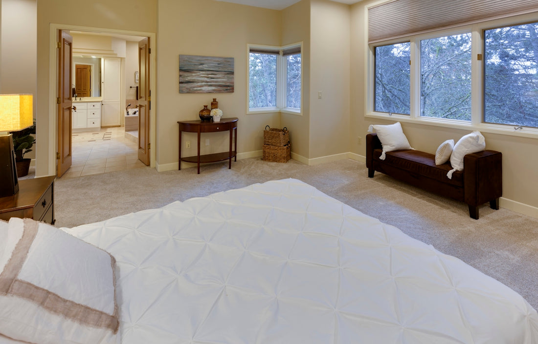 empty bed near open bathroom door