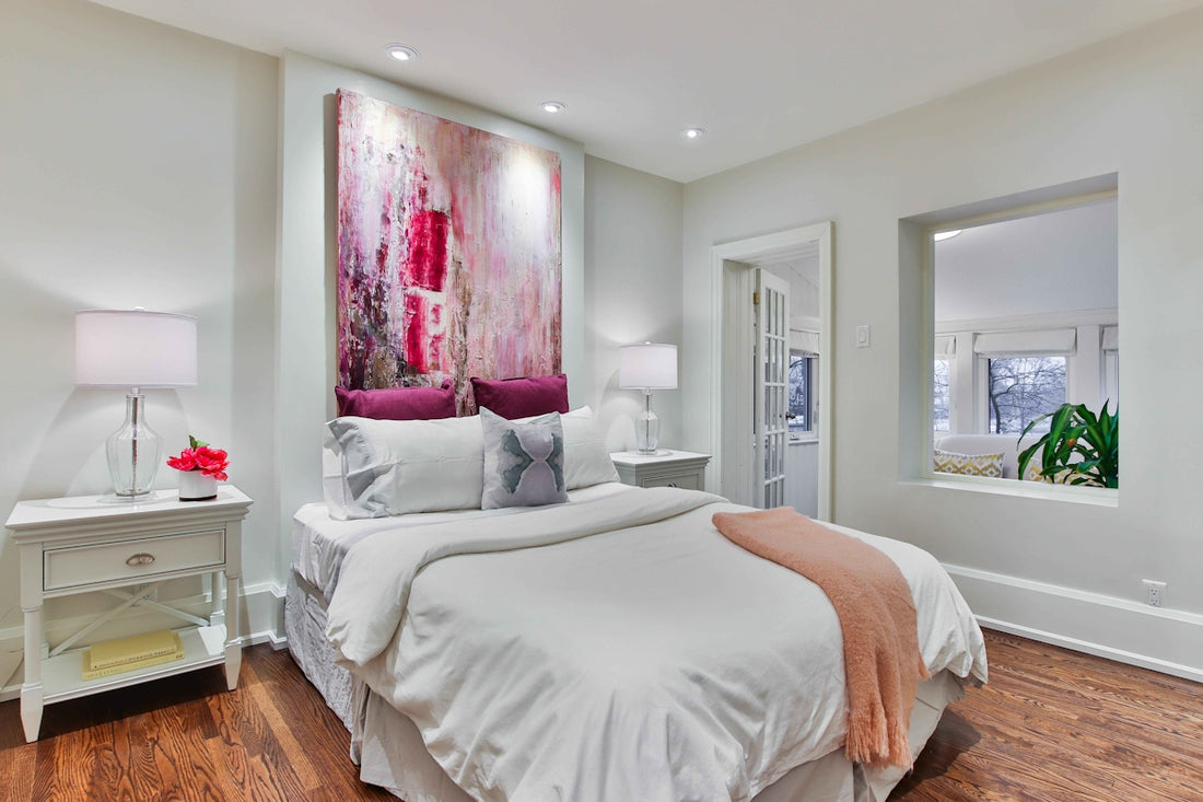 white bed linen near white wooden nightstand