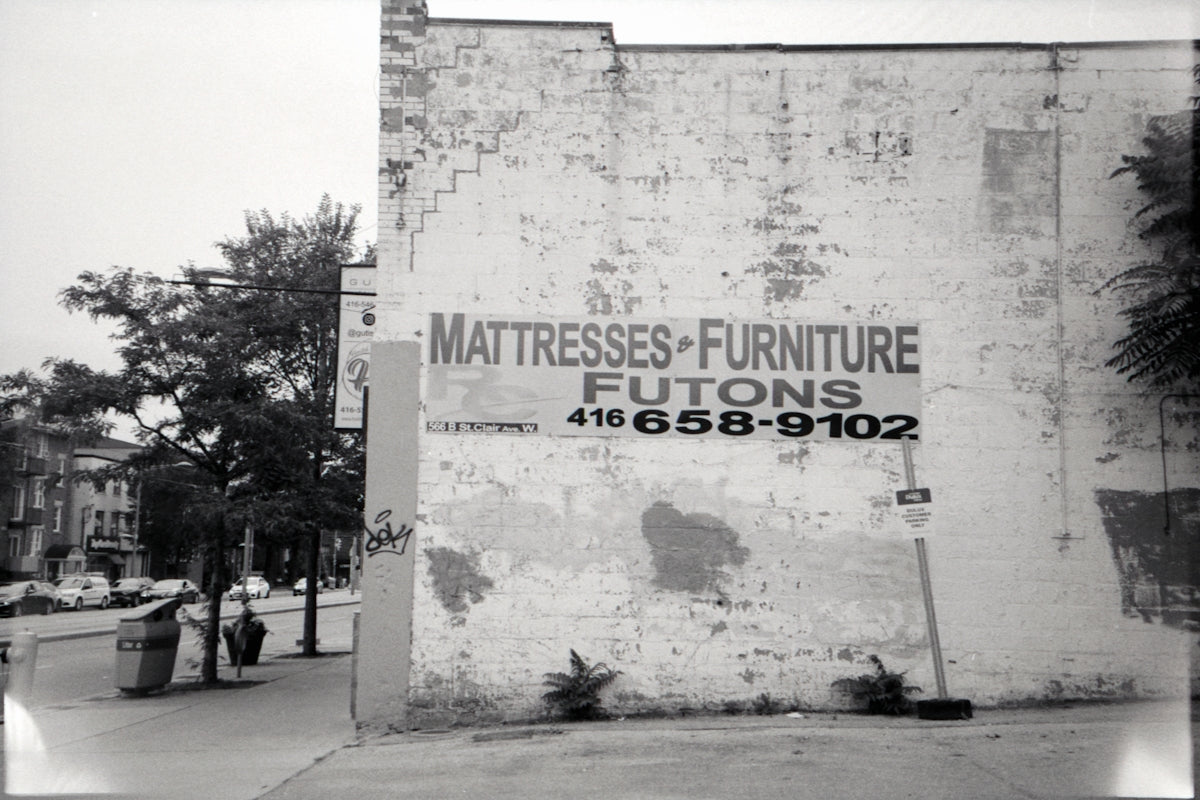 a sign on the side of a building that says mattress - furniture futons