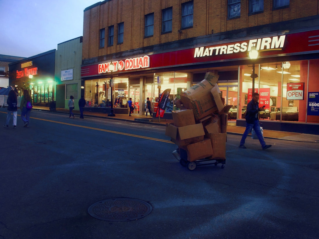 a person pushing a cart full of boxes on a street