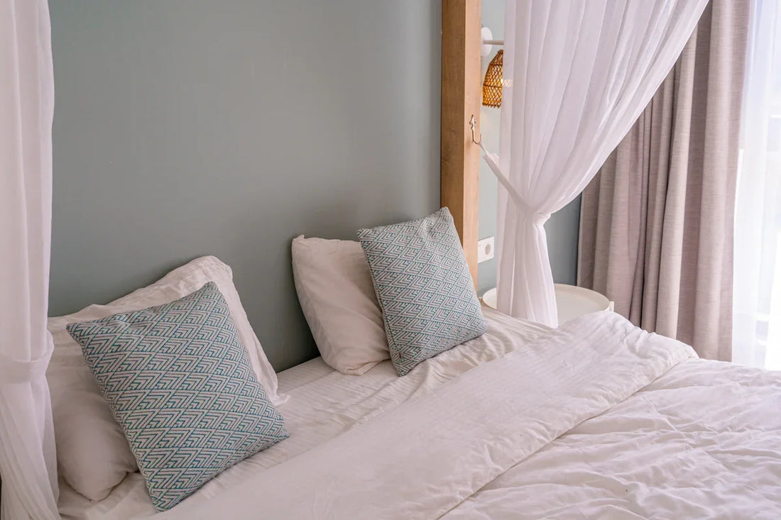 a bed with a white comforter and two pillows