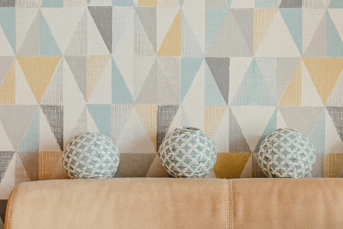 three vases sitting on a couch in front of a wall