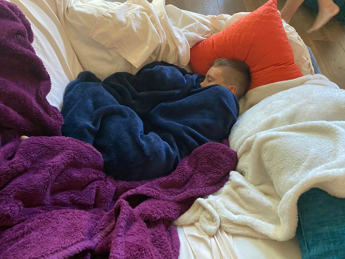 a man sleeping on a bed covered in blankets