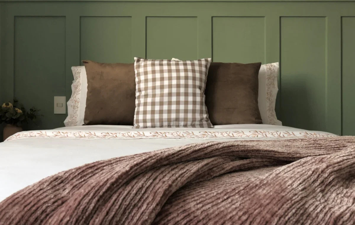 A bed with a blanket and pillows on top of it