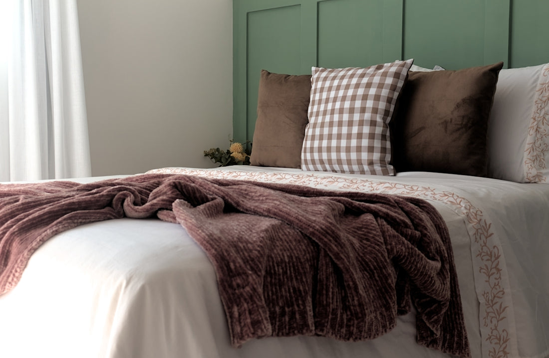 A bed with a blanket and pillows on top of it