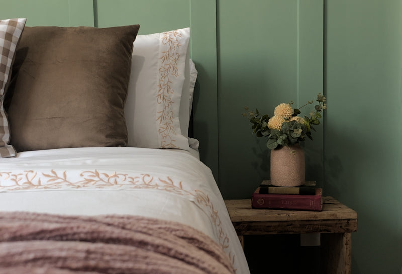 A bed with a brown and white comforter and pillows