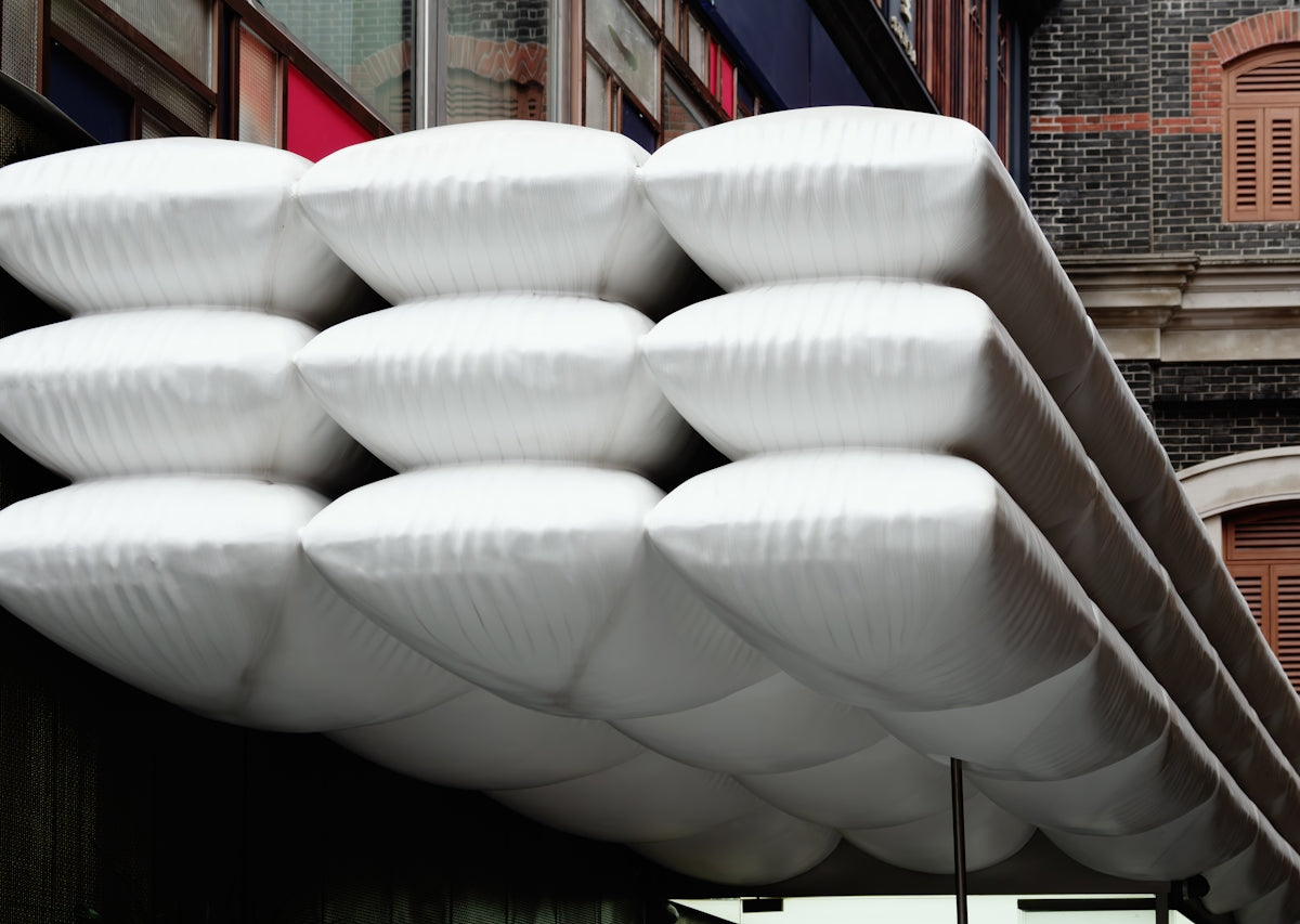 A bunch of white frisbees hanging from the side of a building