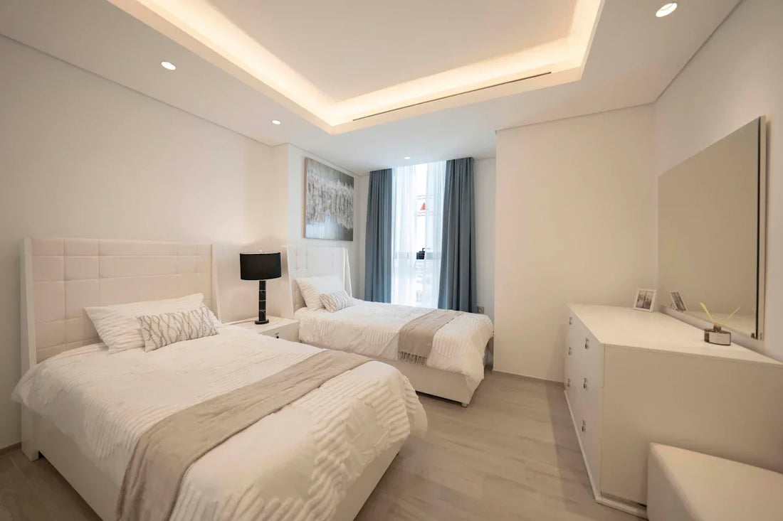 A bedroom with two beds and a desk