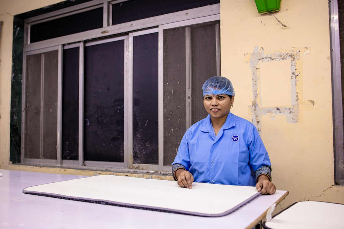 Woman in uniform stands behind a table.