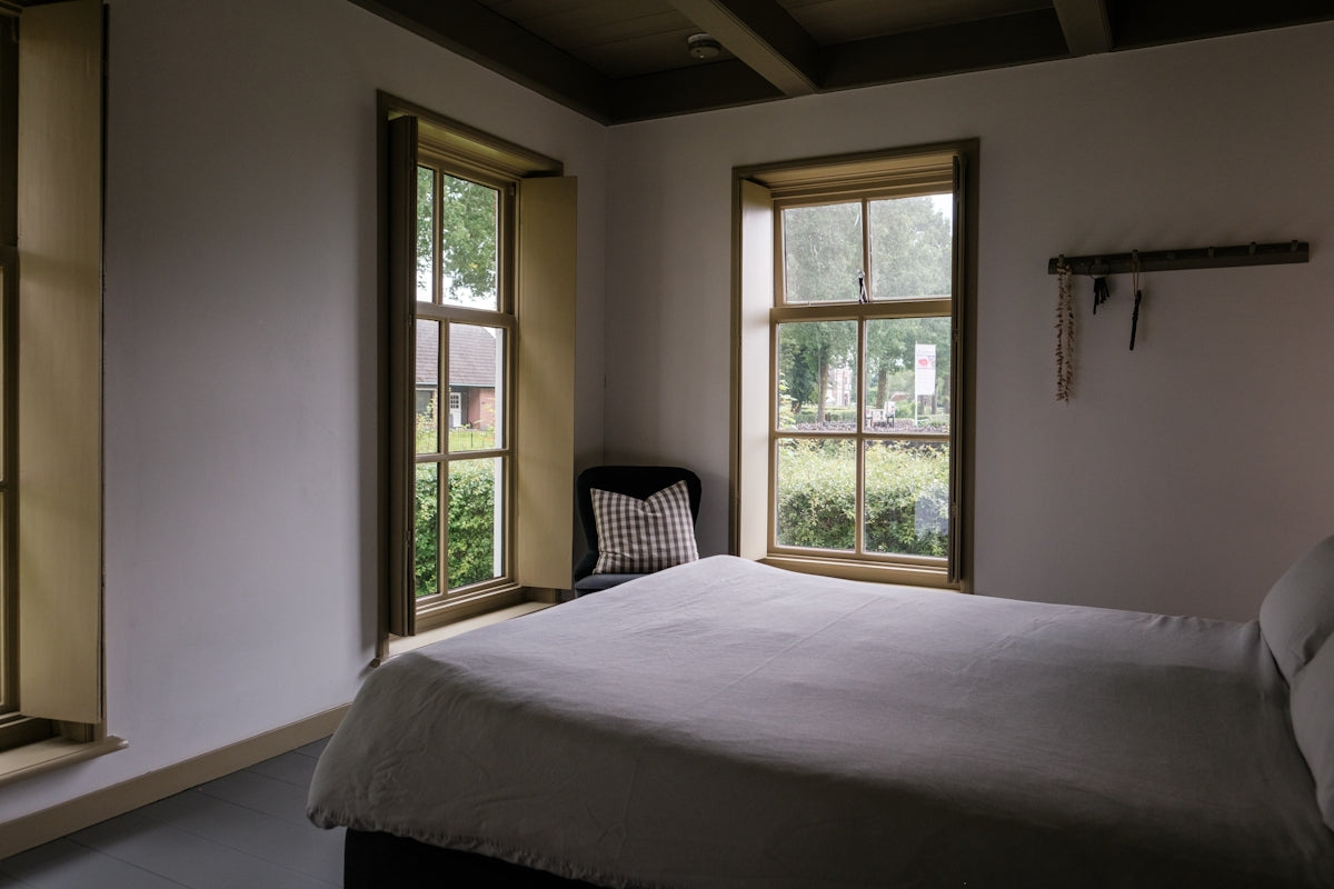 Bedroom with two windows and a cozy bed.