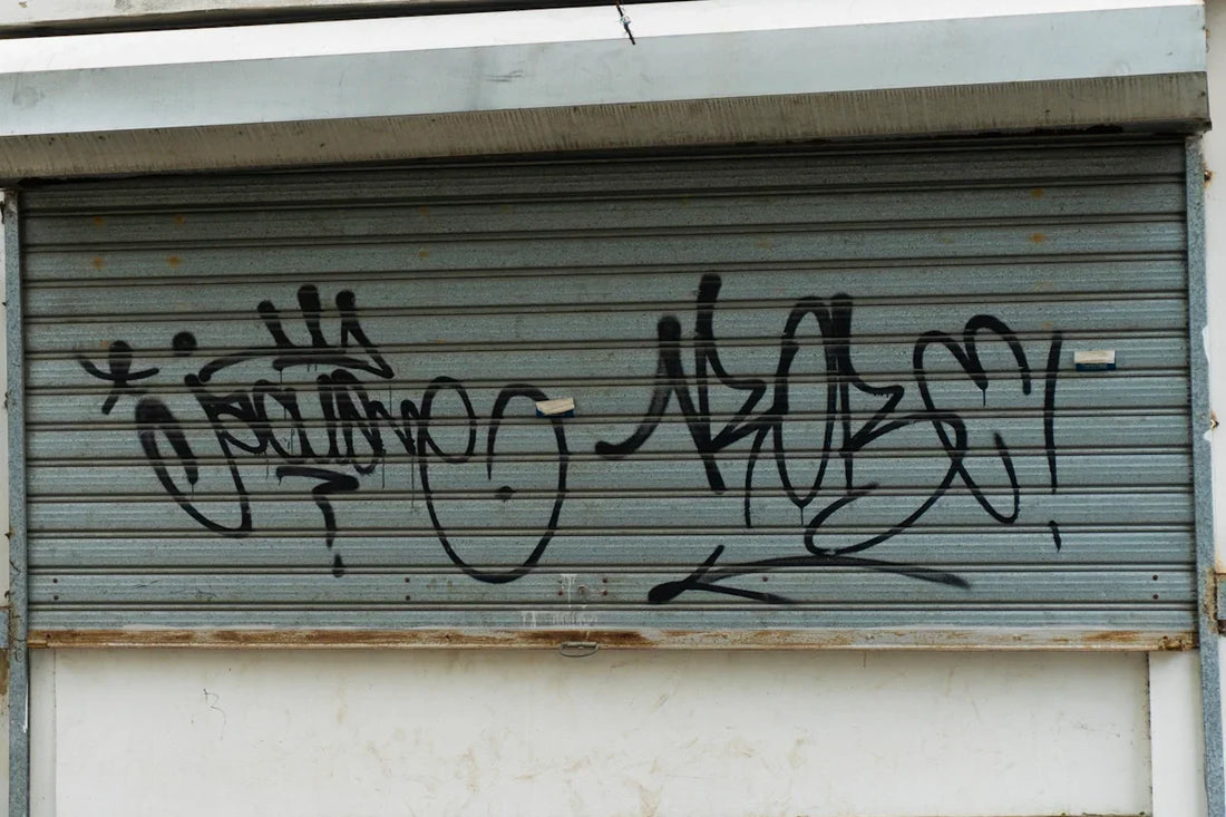 Graffiti covers a closed metal garage door.