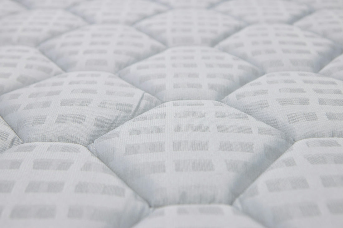 Close-up of a white quilted mattress texture