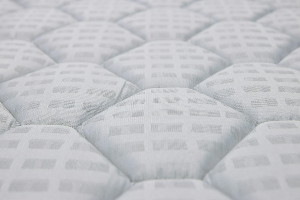 Close-up of a white quilted mattress texture