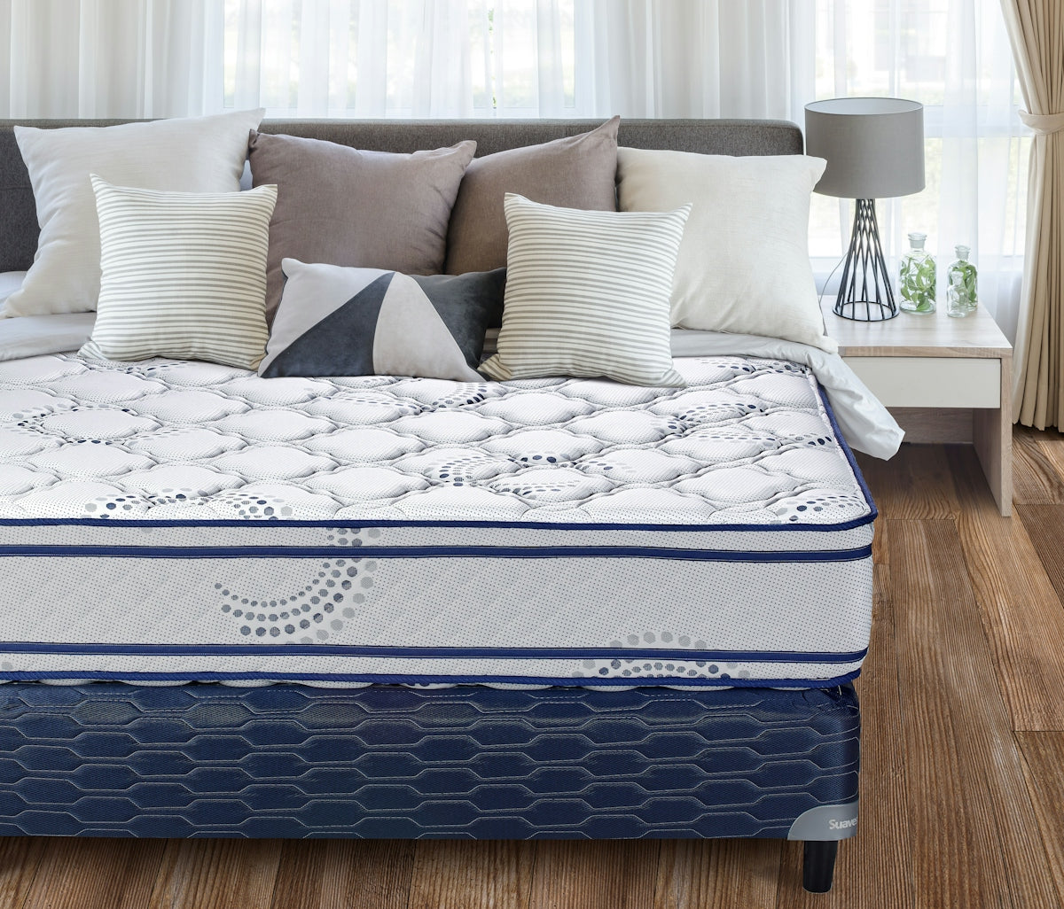 A neatly made bed with a patterned mattress and pillows