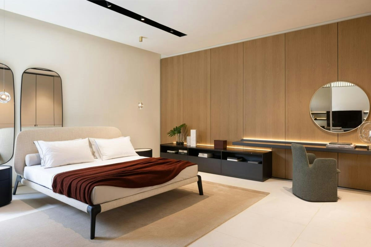Modern bedroom with a bed, desk, and mirrors