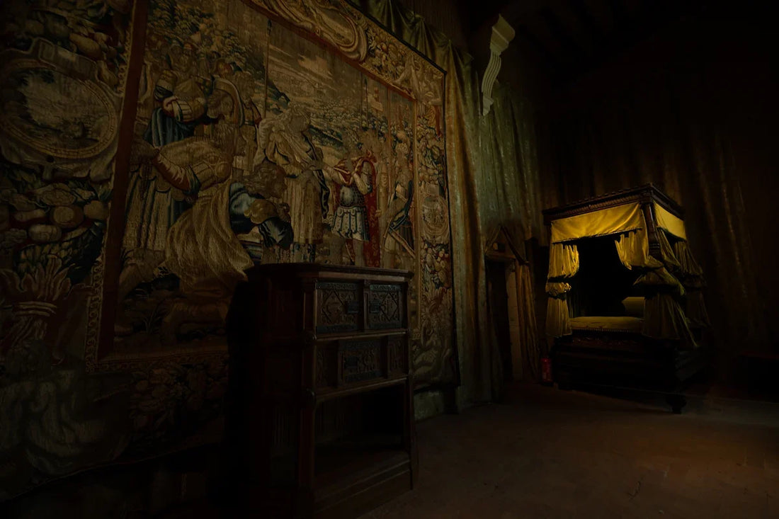 Dimly lit antique bedroom with canopy bed and tapestry.