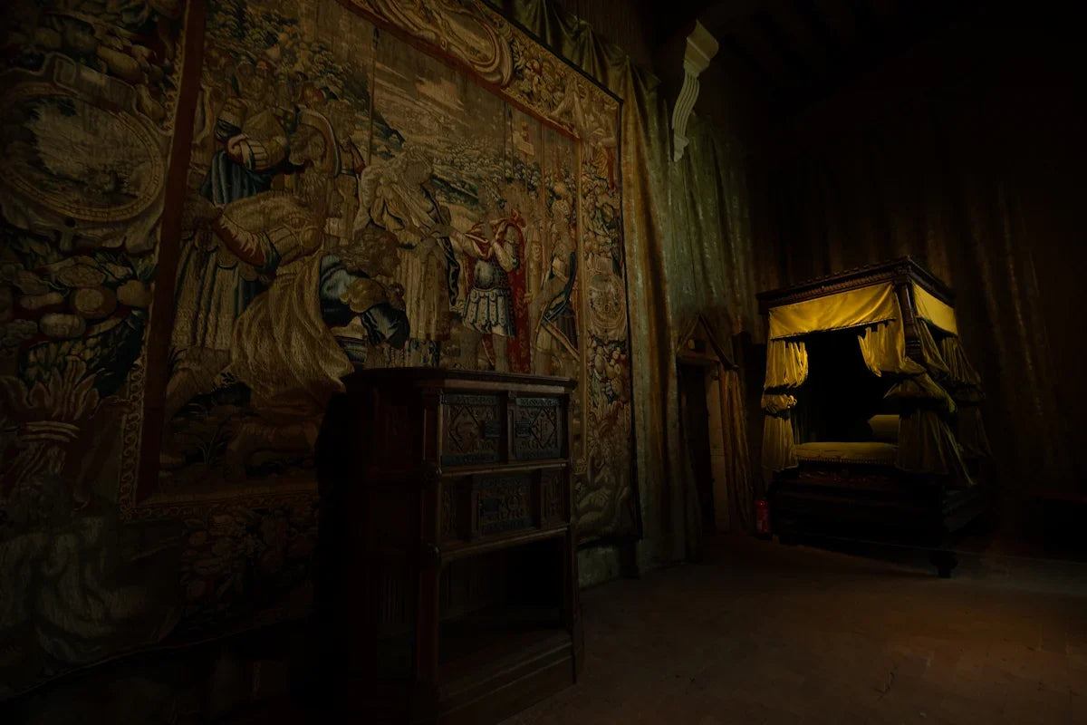 Dimly lit antique bedroom with canopy bed and tapestry.