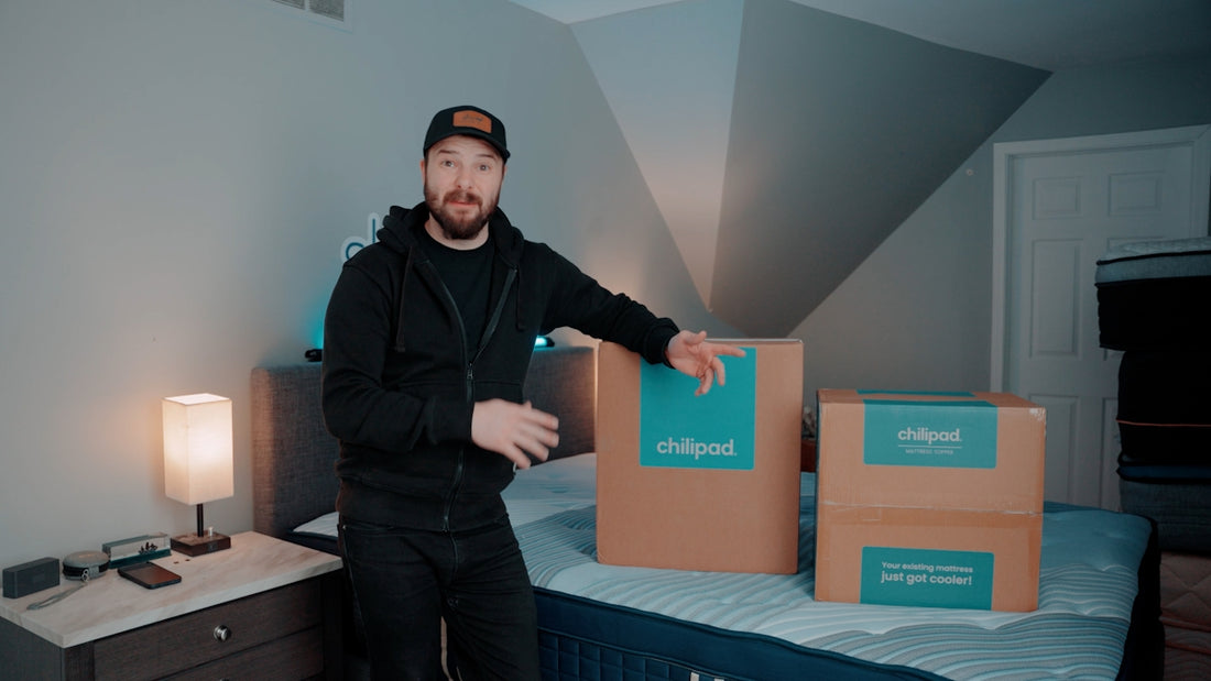 Man standing next to two delivery boxes on a bed