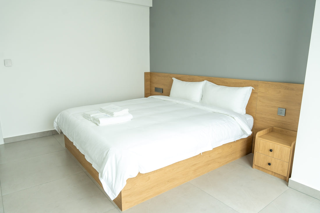 A neatly made bed in a modern hotel room.
