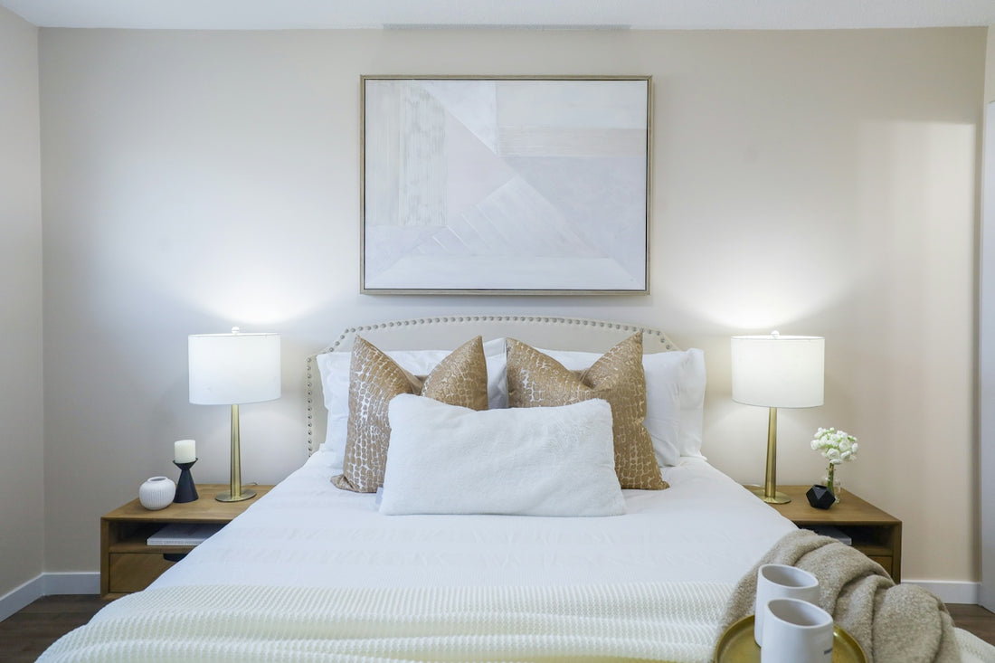 A neatly made bed with decorative pillows and bedside lamps
