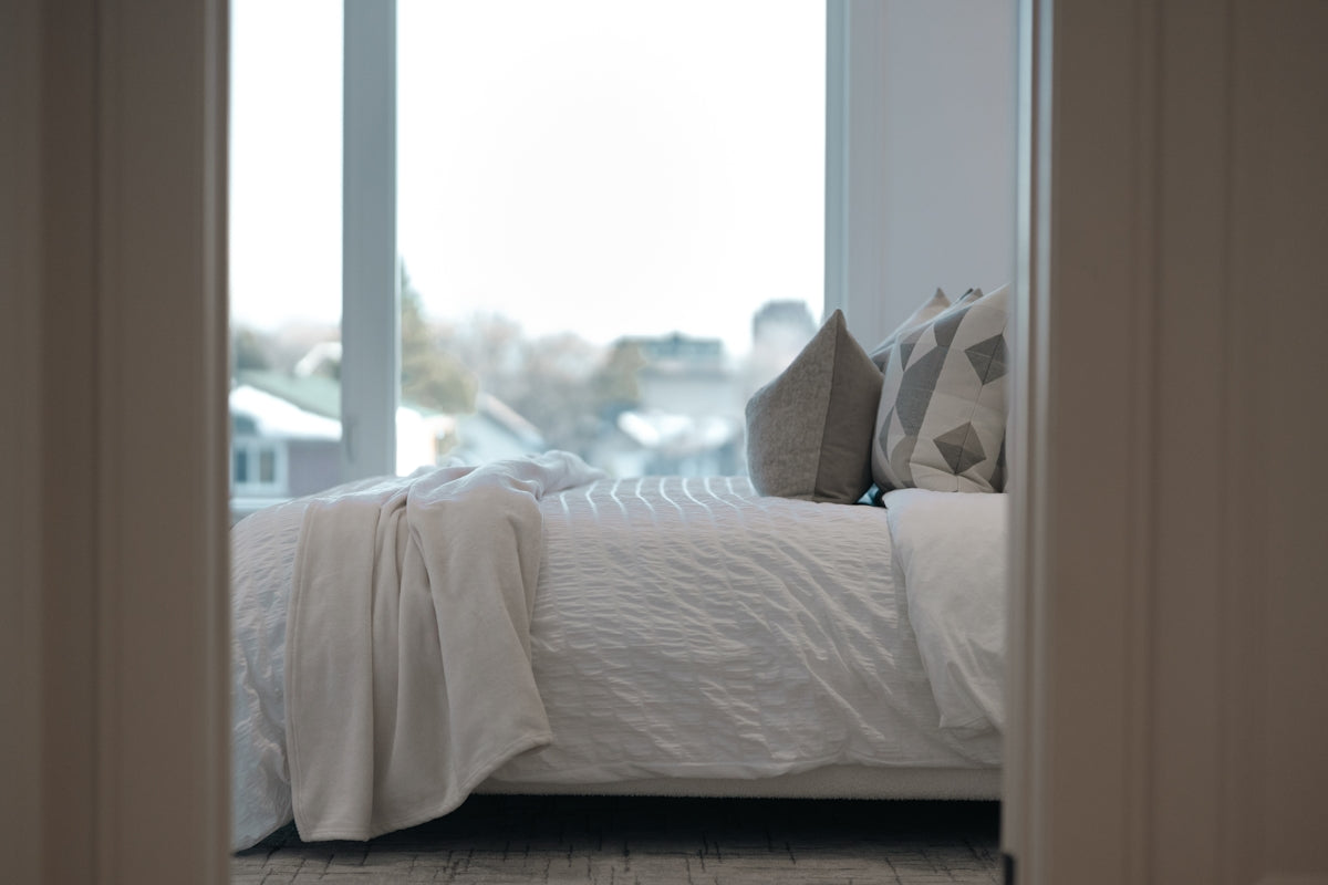 A neatly made bed with pillows and a blanket.