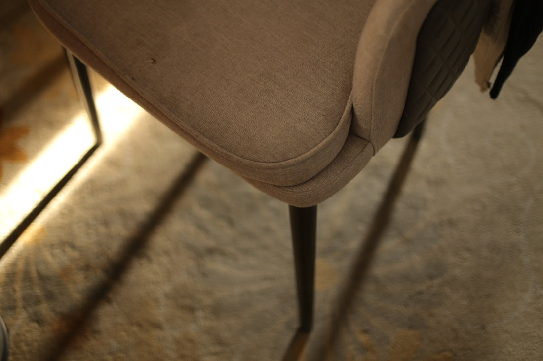 Close-up of a chair leg on a textured floor.