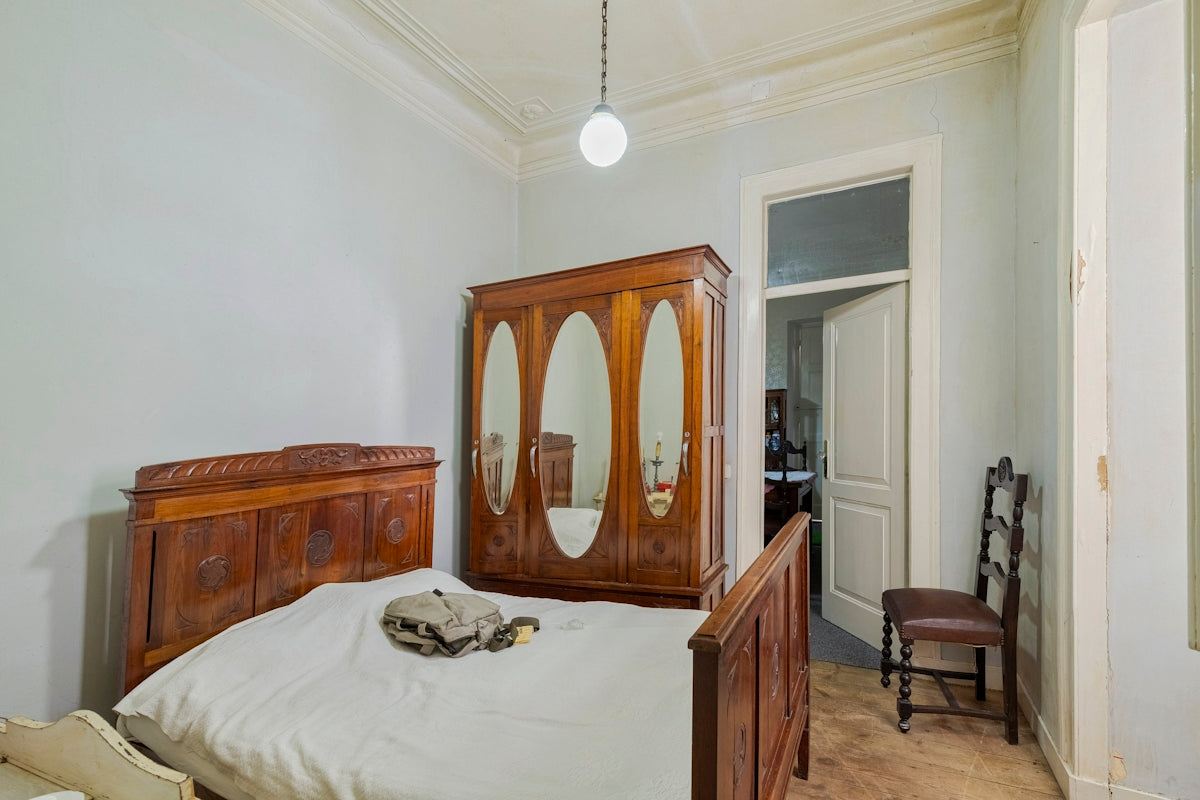Bedroom with antique wooden furniture and a single bed.