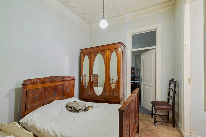Bedroom with antique wooden furniture and a single bed.