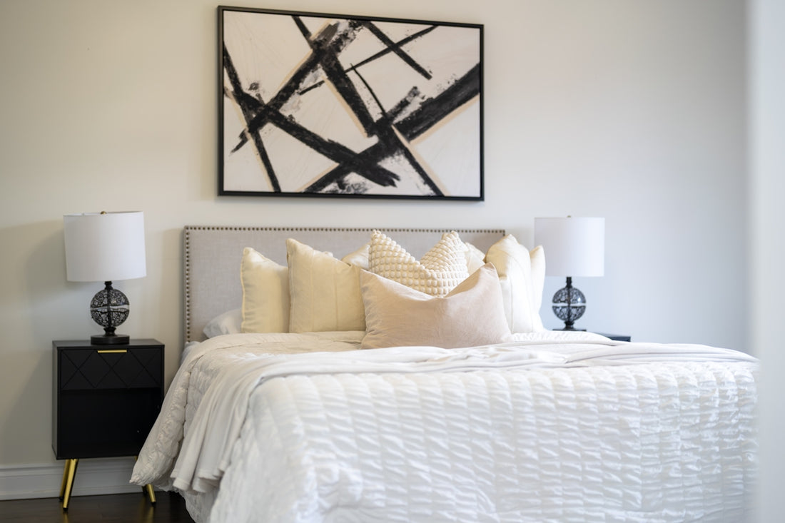A modern bedroom with a king-size bed and abstract art.