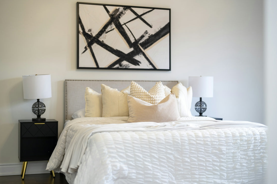 A modern bedroom with a king-size bed and abstract art