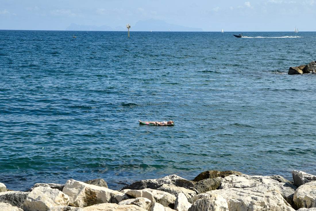 A calm blue ocean with a distant boat and buoy