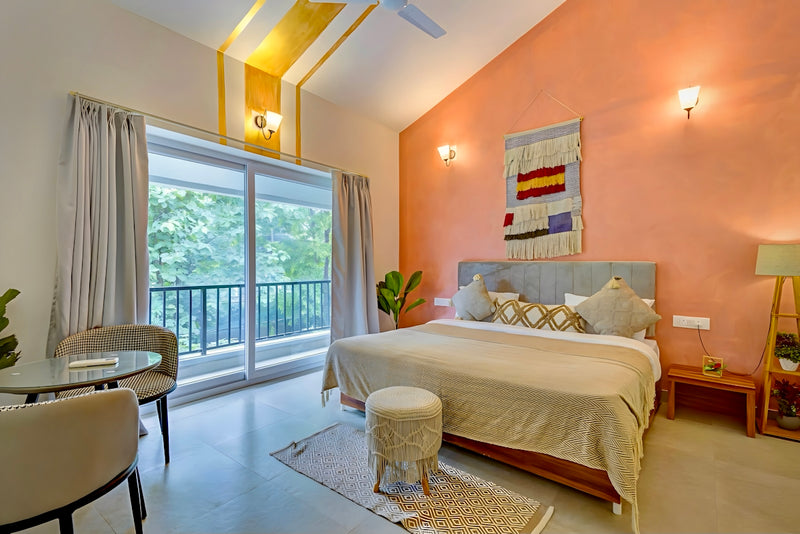 Stylish bedroom with a large bed, balcony, and dining area.