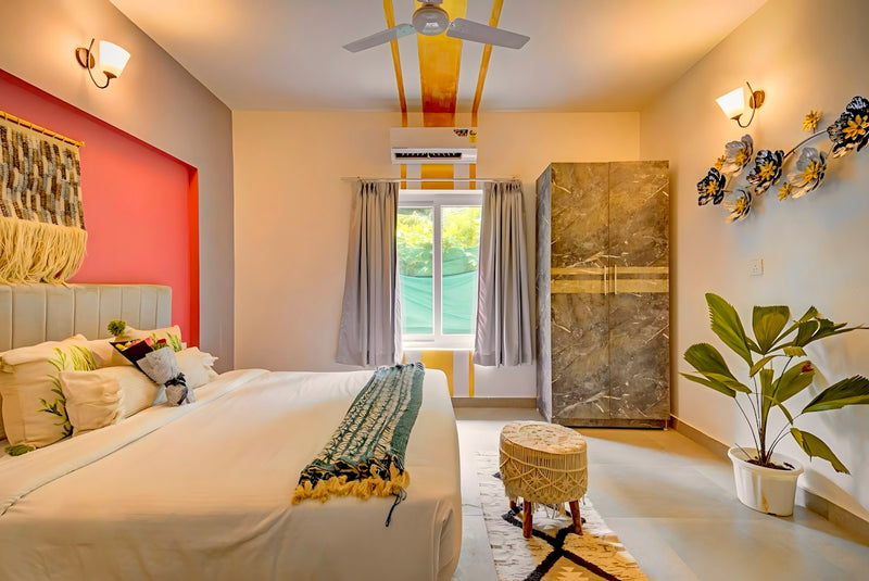 A bright, modern bedroom with a bed, wardrobe, and plant.