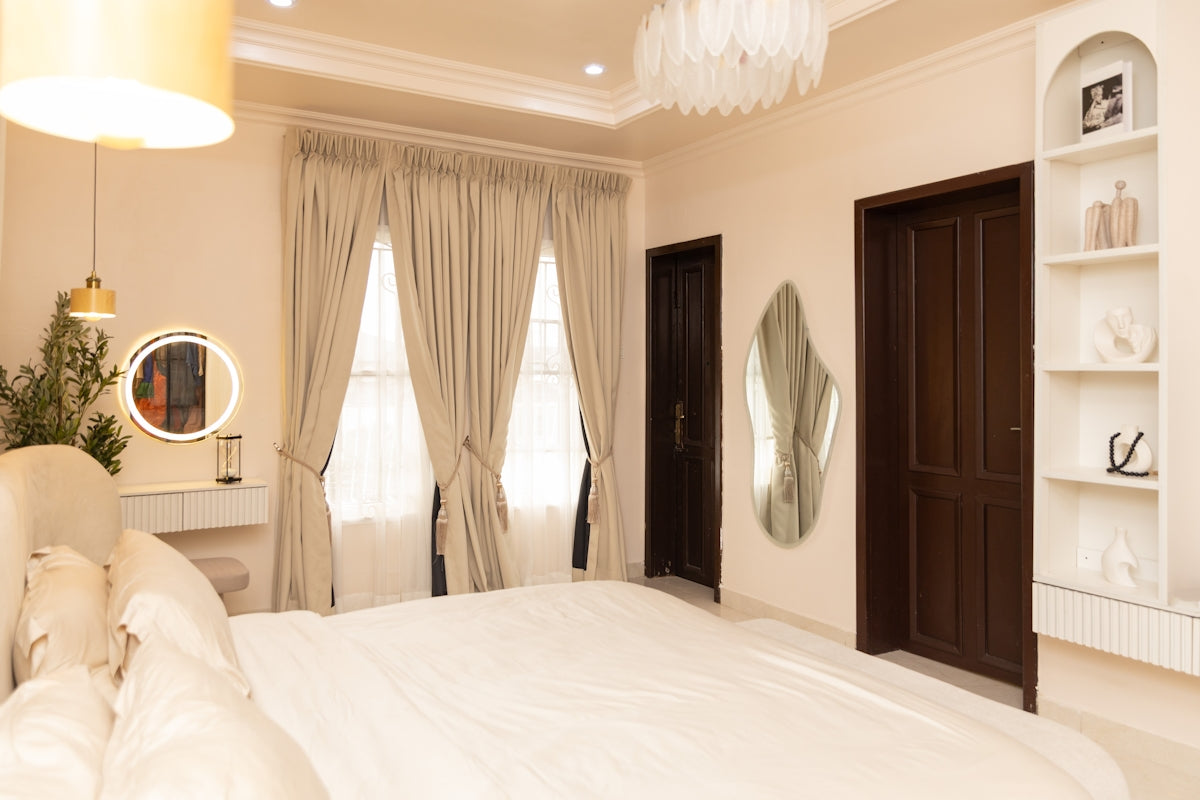Elegant bedroom featuring a bed, vanity, and decorative shelves.