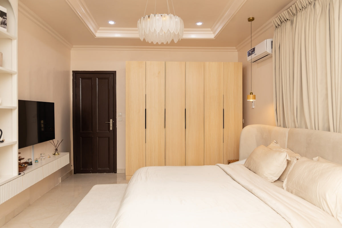 A modern bedroom with a bed, wardrobes, and television.