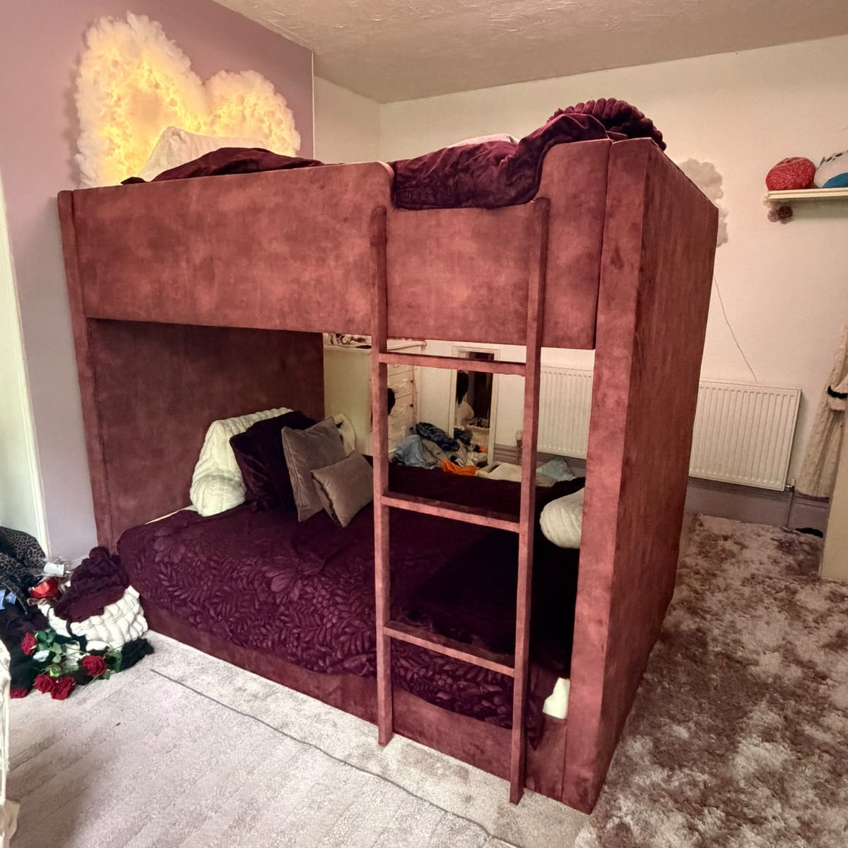 A Ox Blood Coniston bunk bed with a wooden ladder, styled with matching bedding in a child's bedroom.